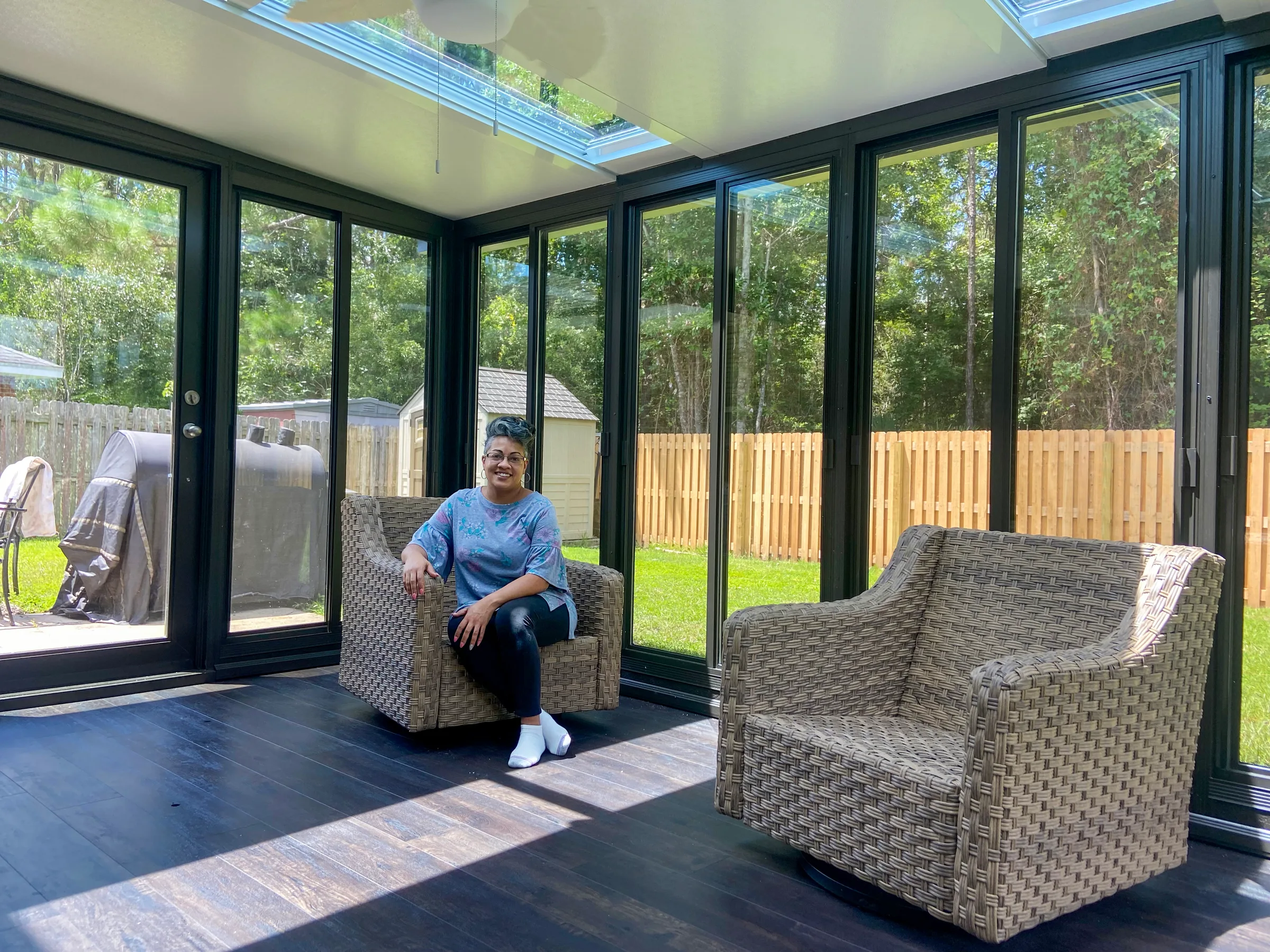 Interior of a TEMO Studio sunroom with bronze framing and a SkyView glass roof letting daylight into a furnished living space